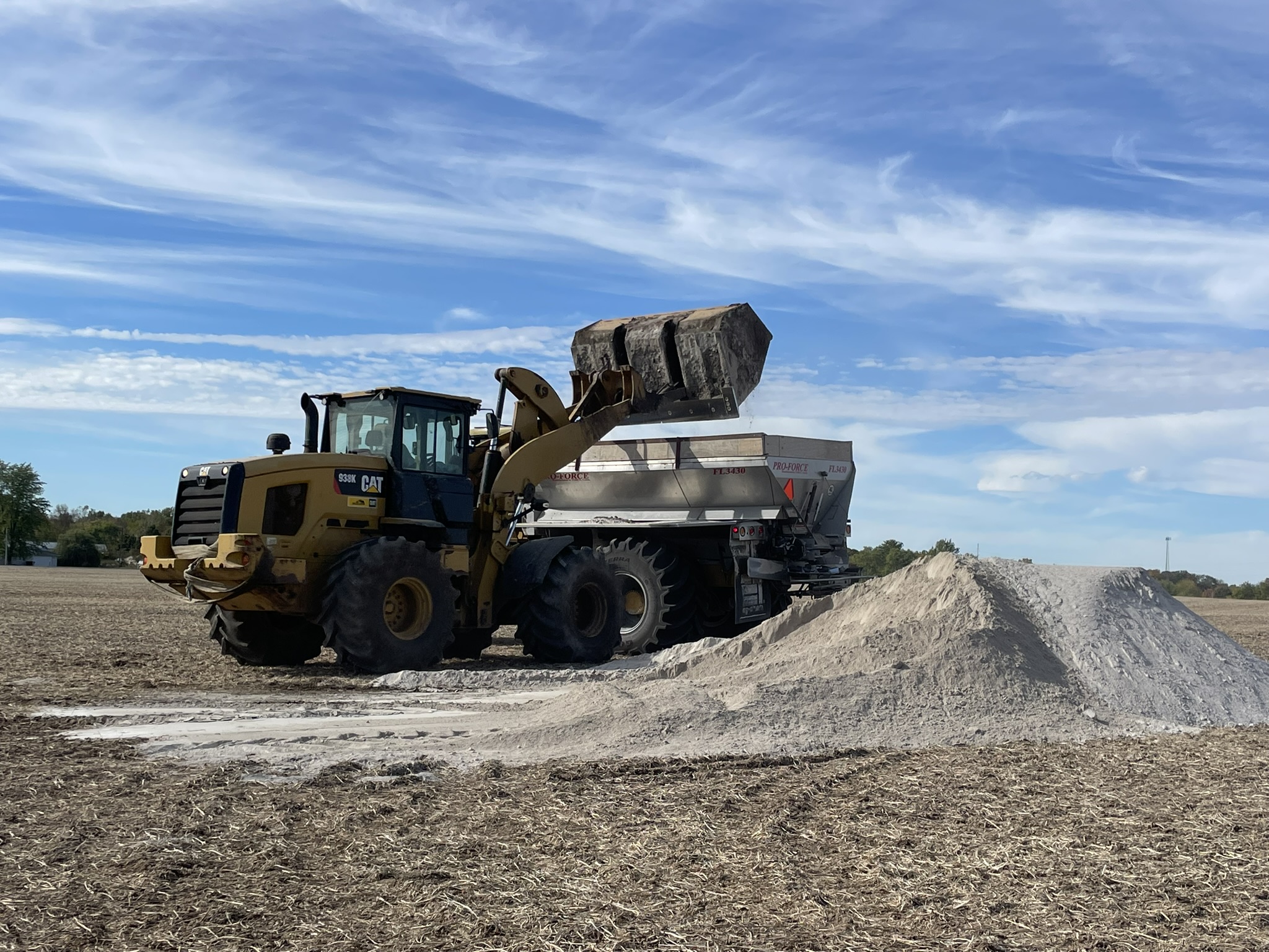 Wheel loader filling spreader at lime pile