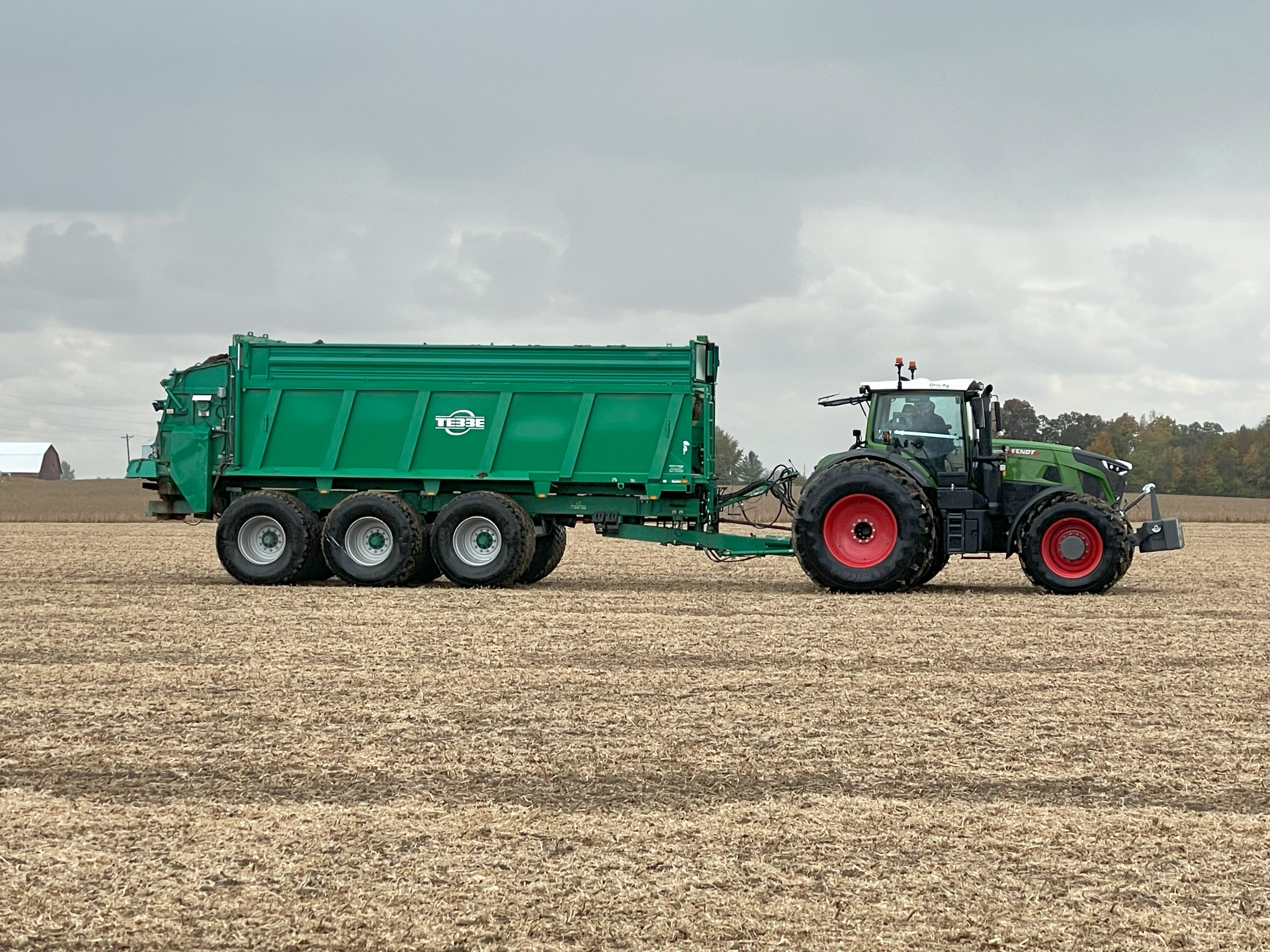 Manure spreader and tractor in field operation